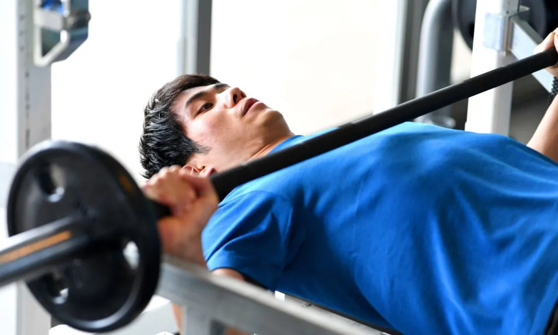 ベンチプレスでトレーニングする男性